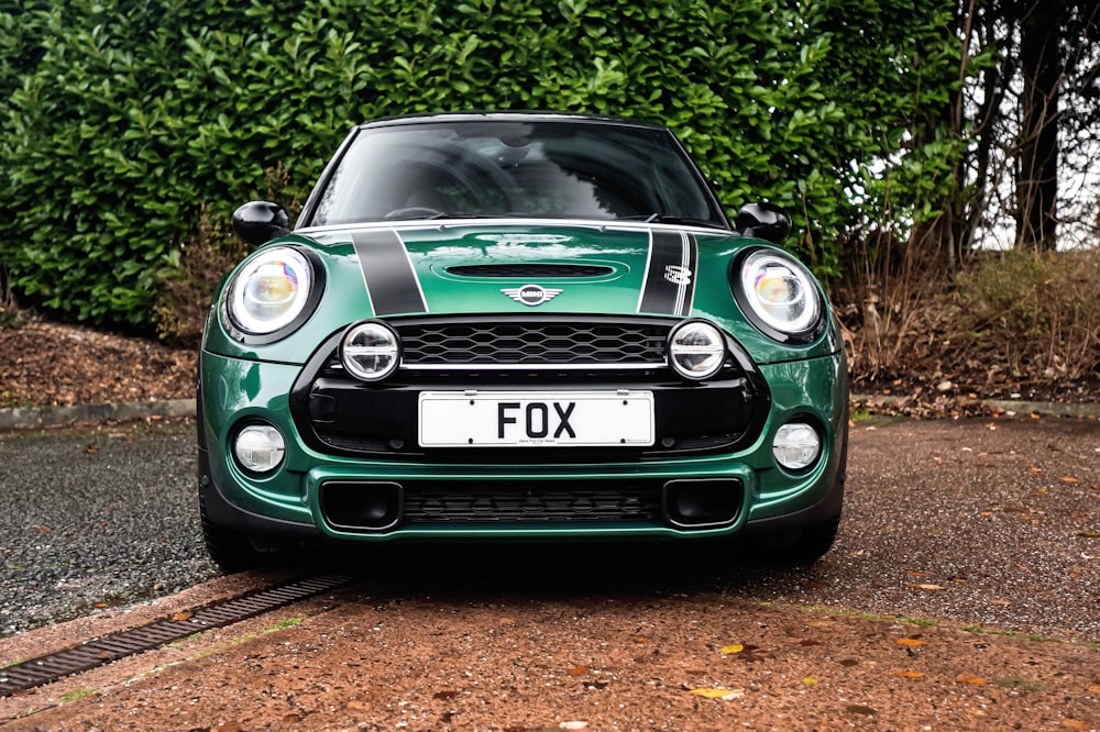 a small green car parked on the side of a road