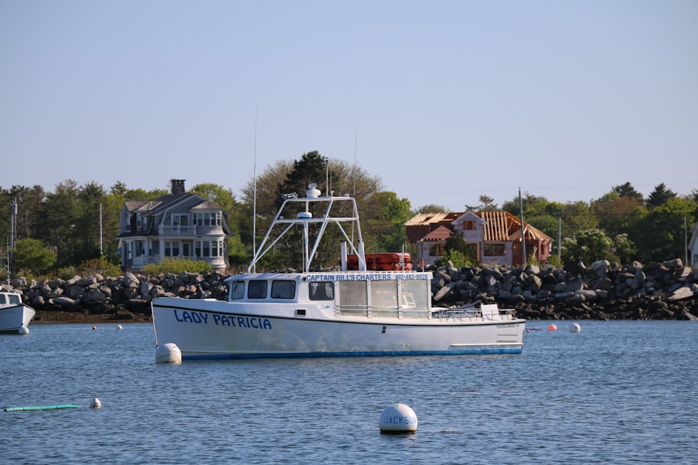 a white boat floating on top of a body of water