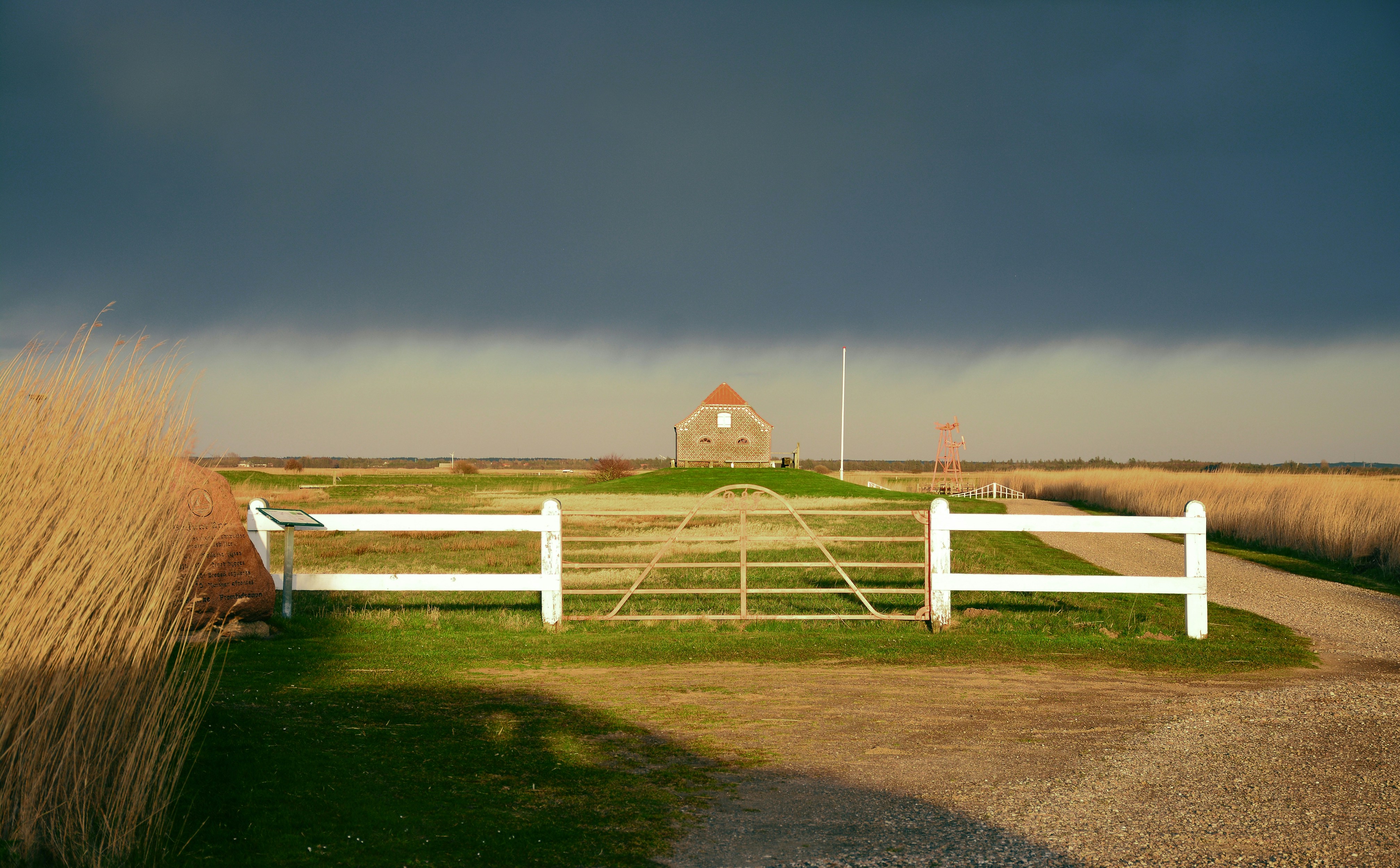 Ein Bauernhof mit einem weißen Zaun und einer Scheune im Hintergrund