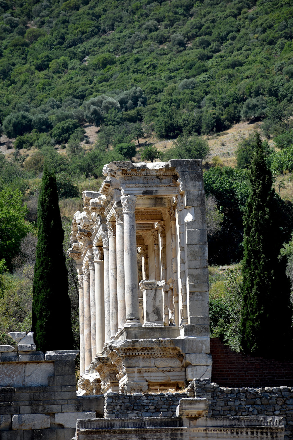 a large stone structure with columns and a clock on top of it