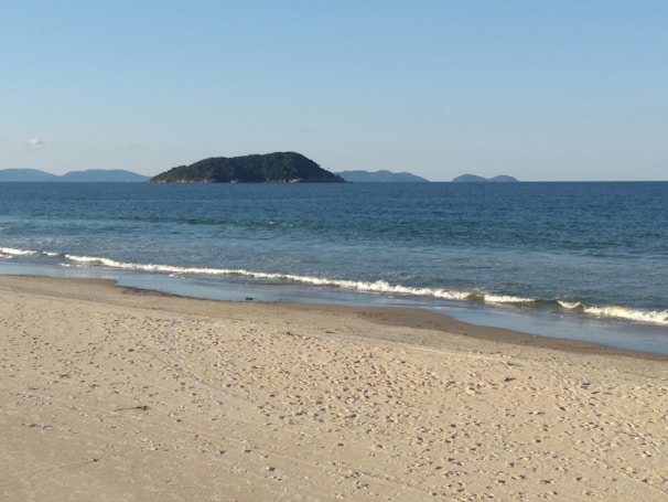 Sunlit sandy beach with turquoise waves gently rolling onto the shore of Quan Lạn Island