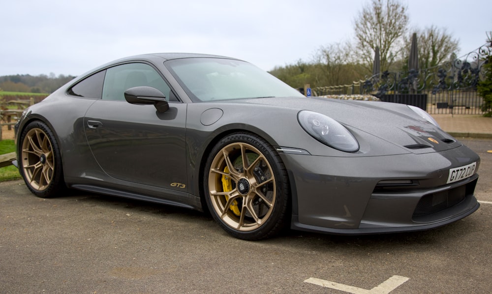 a grey sports car parked in a parking lot