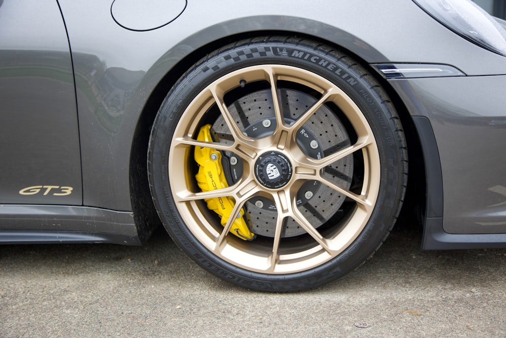 a grey sports car with yellow brake pads