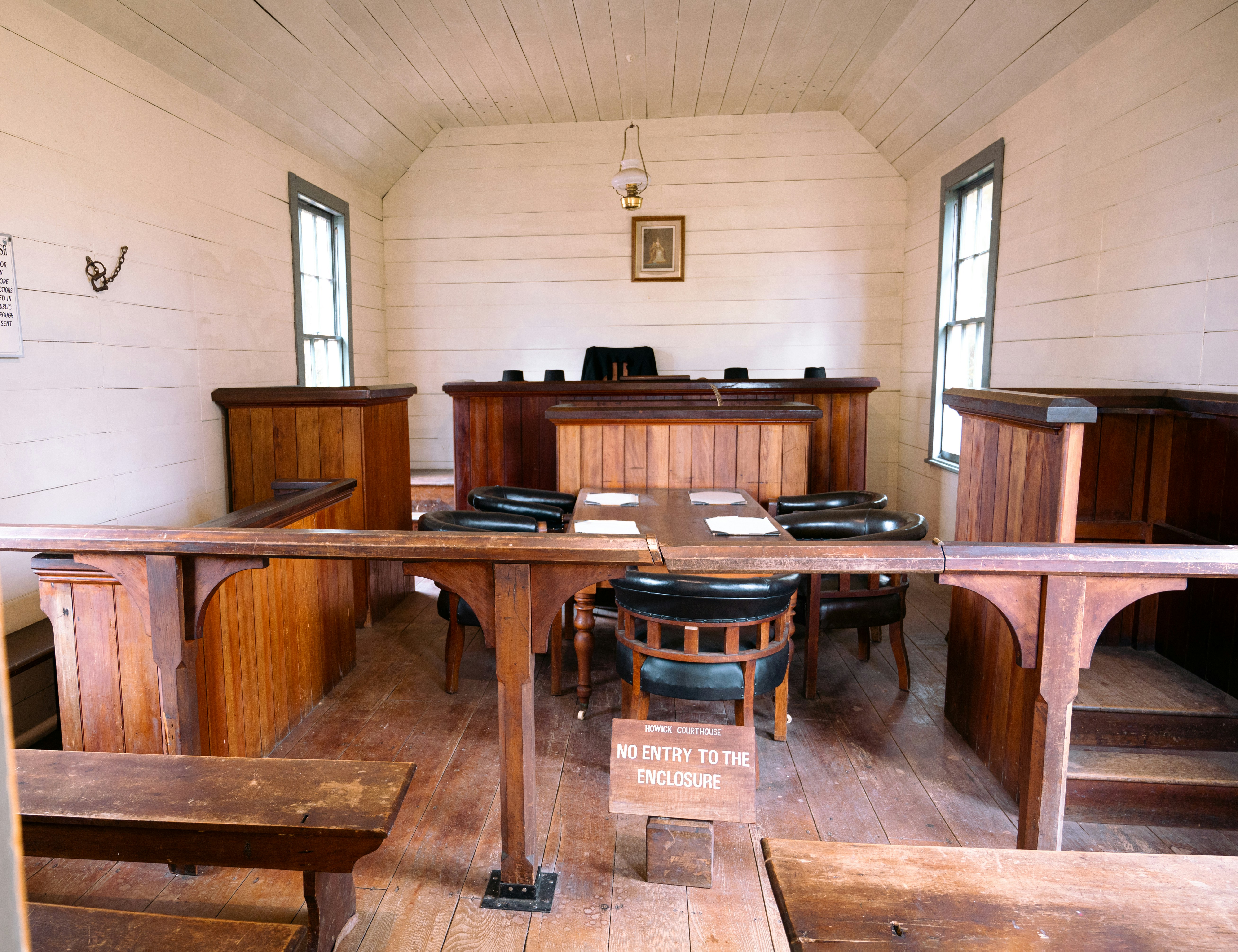 a courtroom with wooden benches and a wooden table