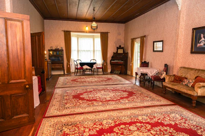 A cozy living space adorned with a large, elegant Persian rug in deep red and beige tones.