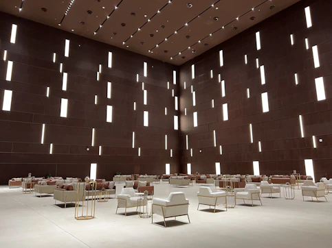 Minimalist interior featuring high-end furniture pieces against a crisp white backdrop with subtle gold accents.