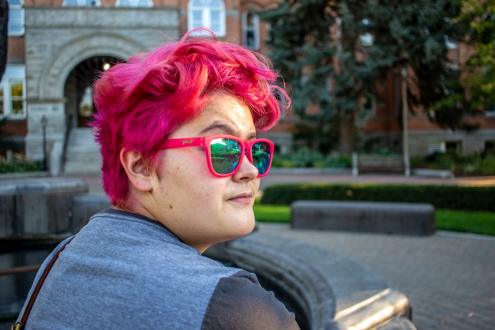 a person with pink hair and sunglasses on