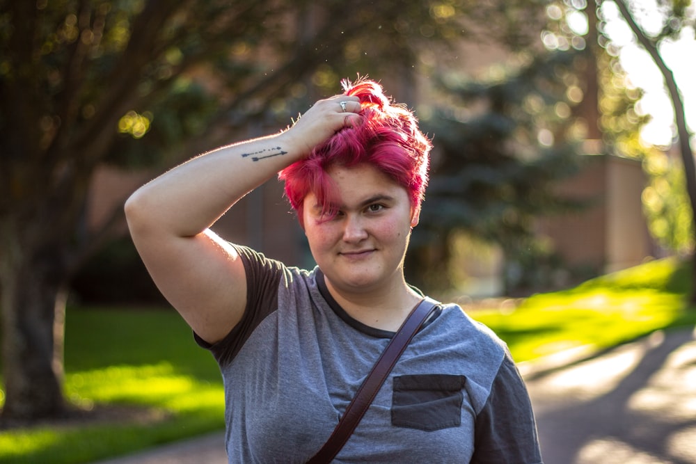 a woman with pink hair and a grey shirt