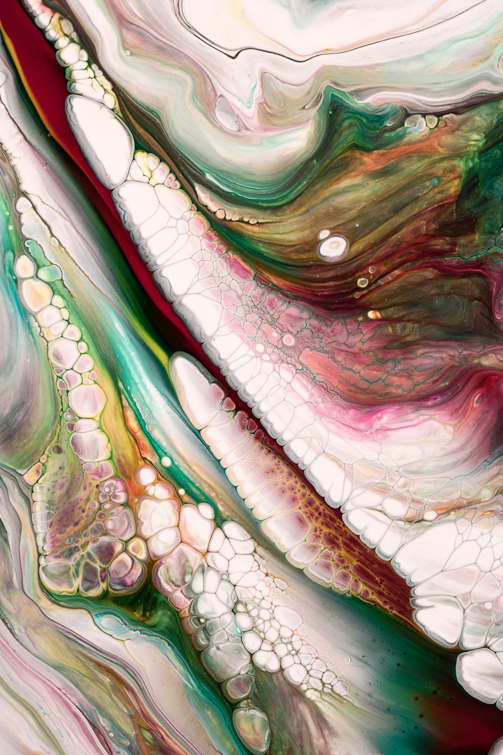 a close up of an abstract painting with red, green, and white colors