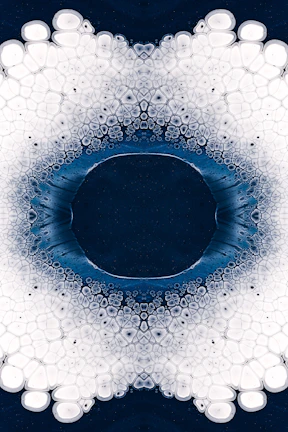 A symmetrical blue and green mandala with delicate leaf motifs radiating from the center.