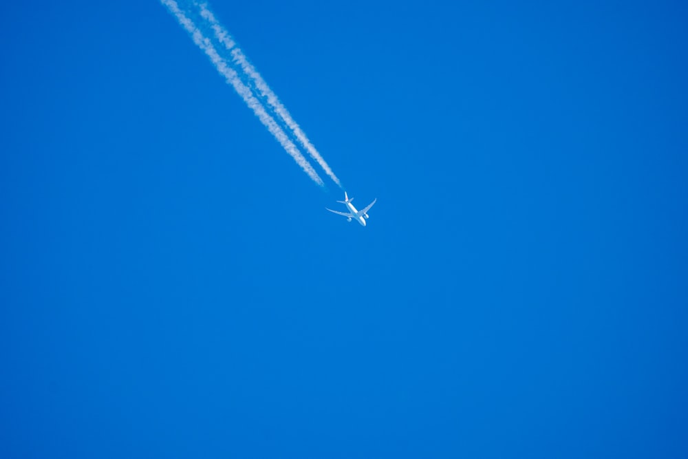 an airplane is flying in the blue sky