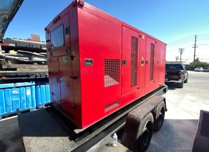 Technician inspecting a standby generator outdoors on a sunny day.