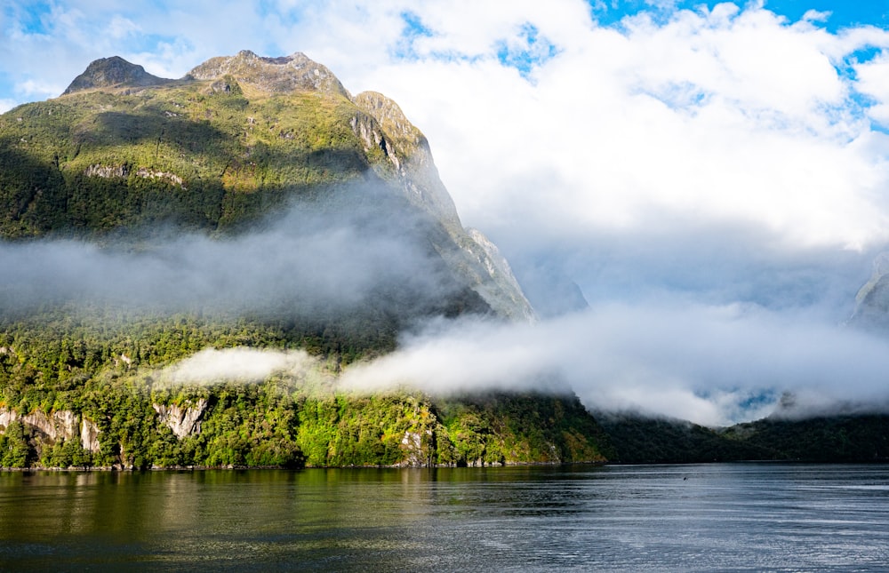 a body of water surrounded by mountains and clouds