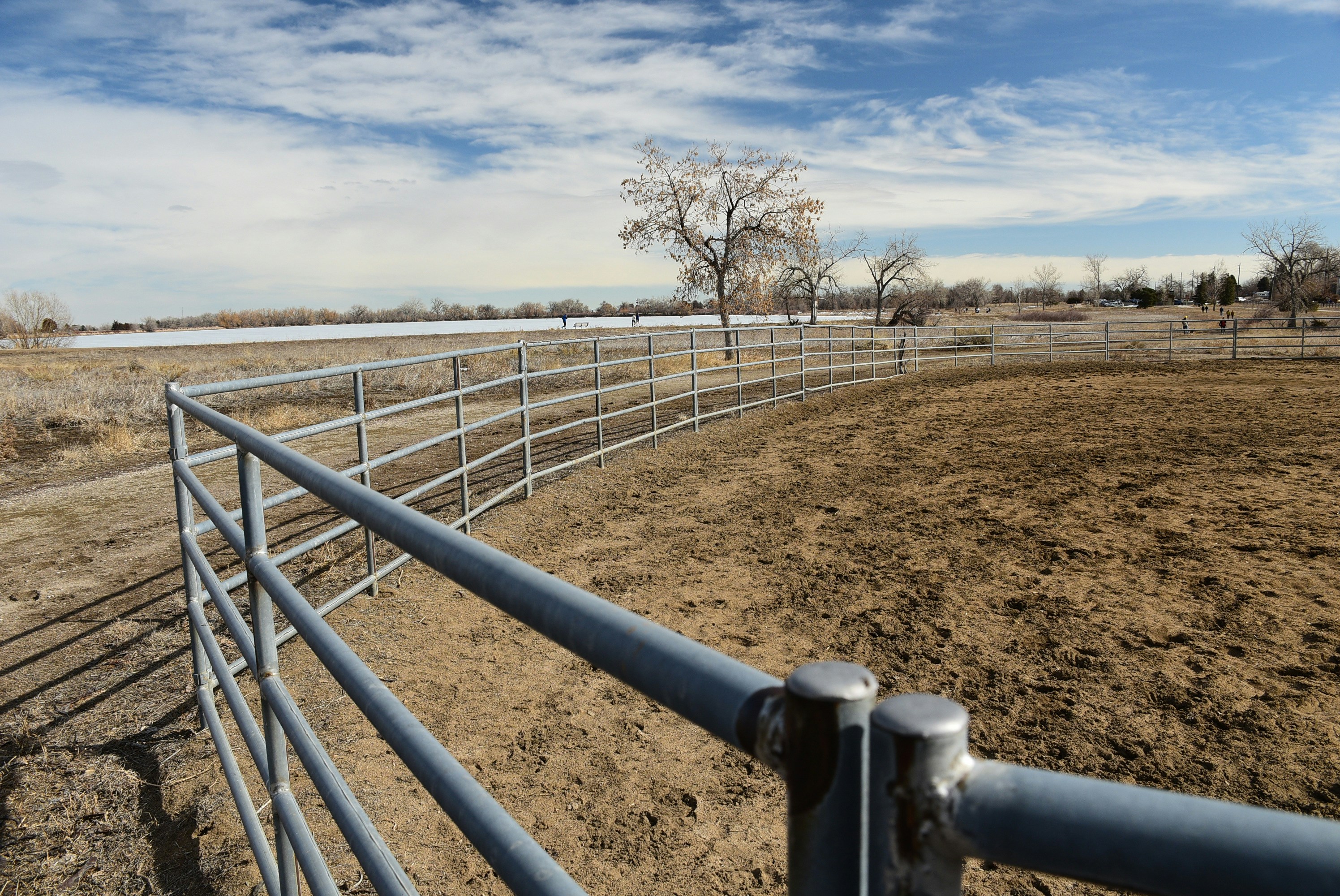 a fenced in area with a field in the background