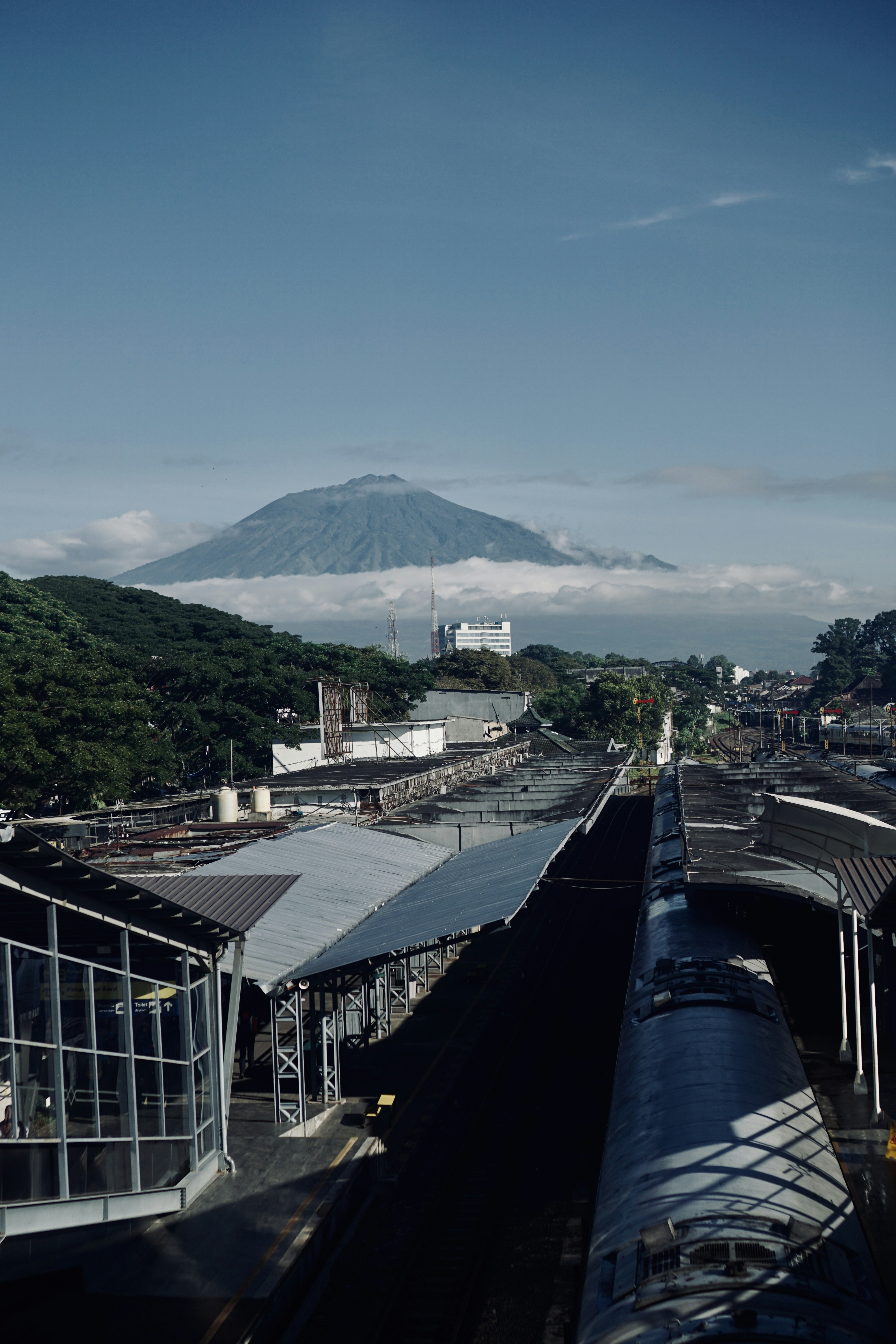 kereta api yang melaju menyusuri rel kereta api di sebelah gunung