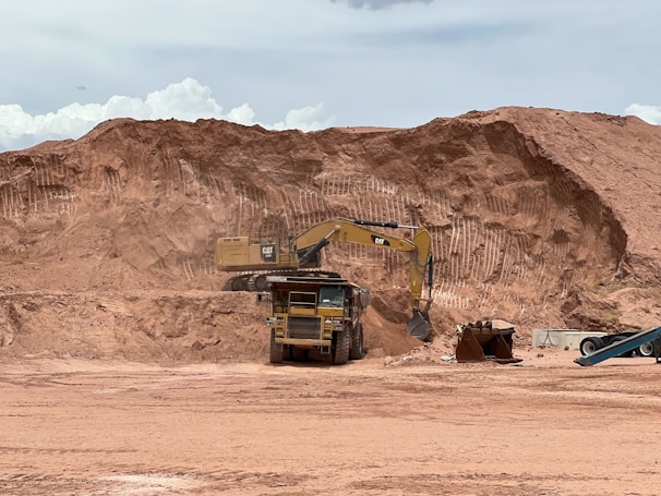 Close-up shot of a Komatsu wheel loader maneuvering heavy materials amidst dusty terrain.