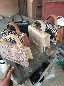 A collection of stylish bags displayed on a wooden table with natural light highlighting their textures.