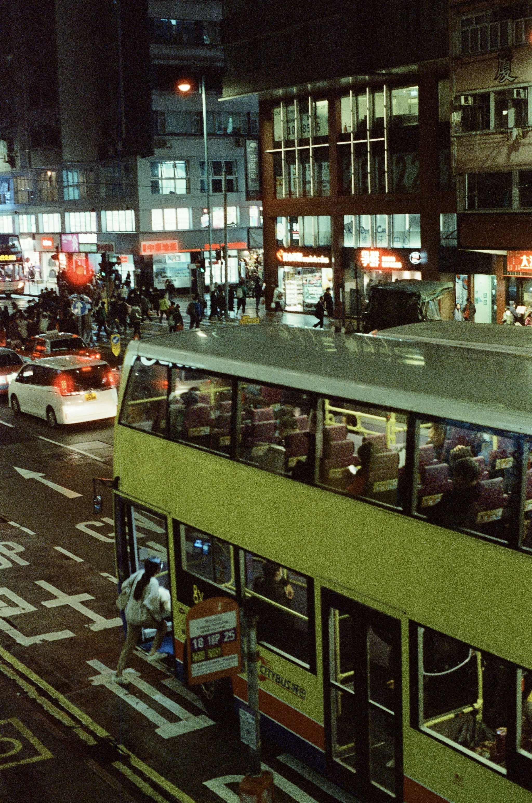 a double decker bus driving down a street at night