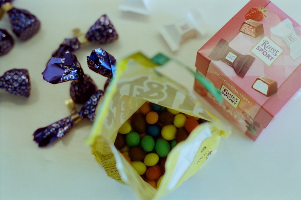 a bag of candy next to a box of candies