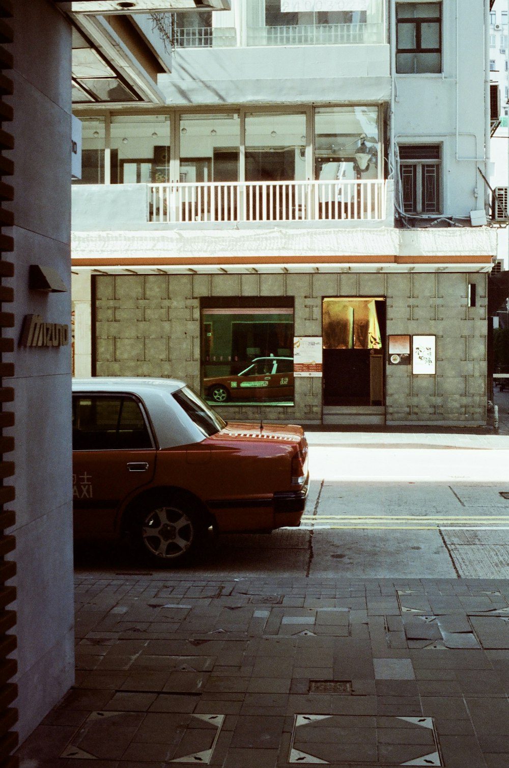 a red car parked in front of a tall building