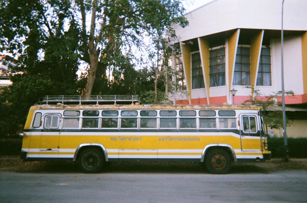 Ein gelb-weißer Bus parkt vor einem Gebäude