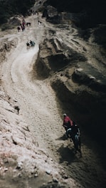 A group of travelers riding horses through a misty Andean mountain trail at sunrise.