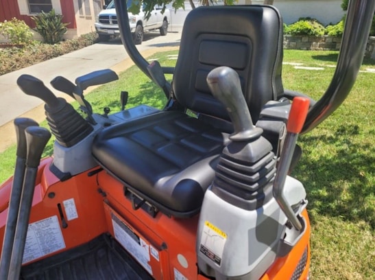 Close-up of mini excavator controls and operator seat.