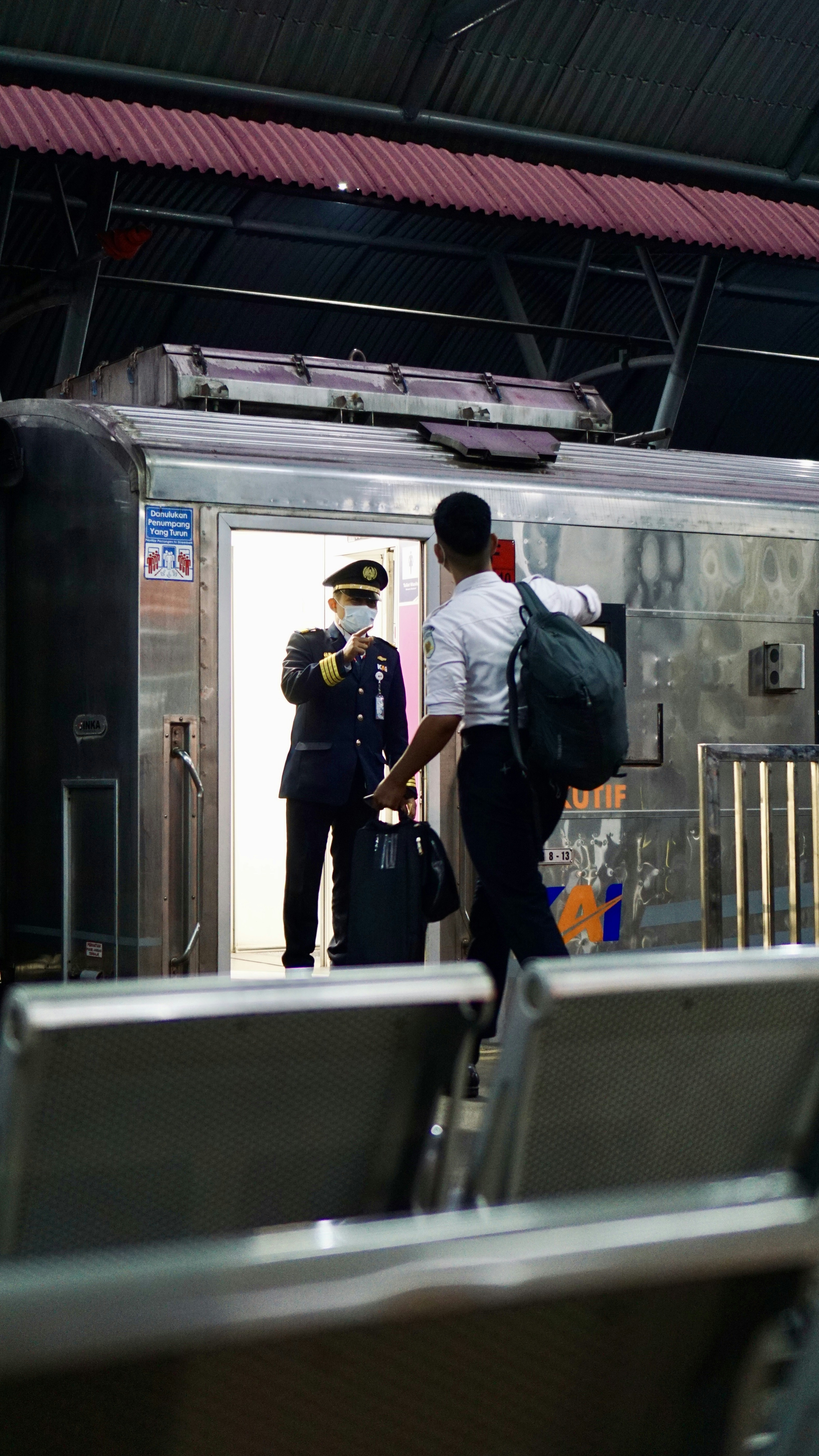 a couple of men standing next to a train