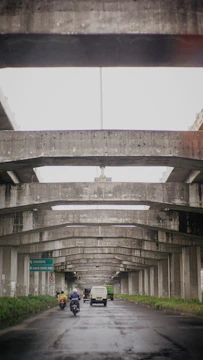 A wide view of the Jakarta-Cikampek toll road under construction with heavy machinery and workers.