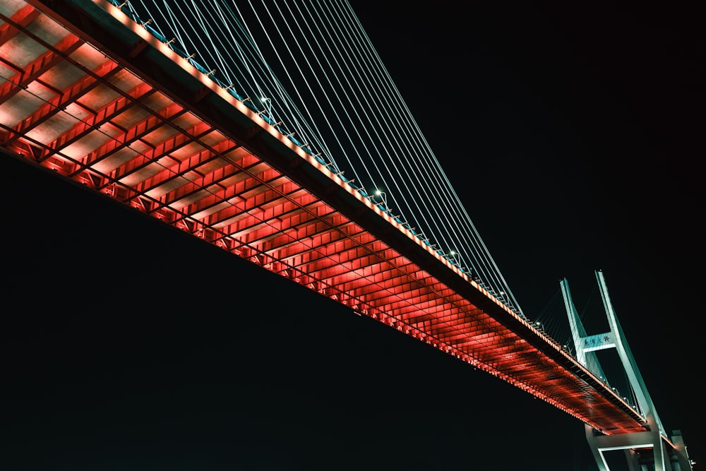 a bridge lit up with red lights at night