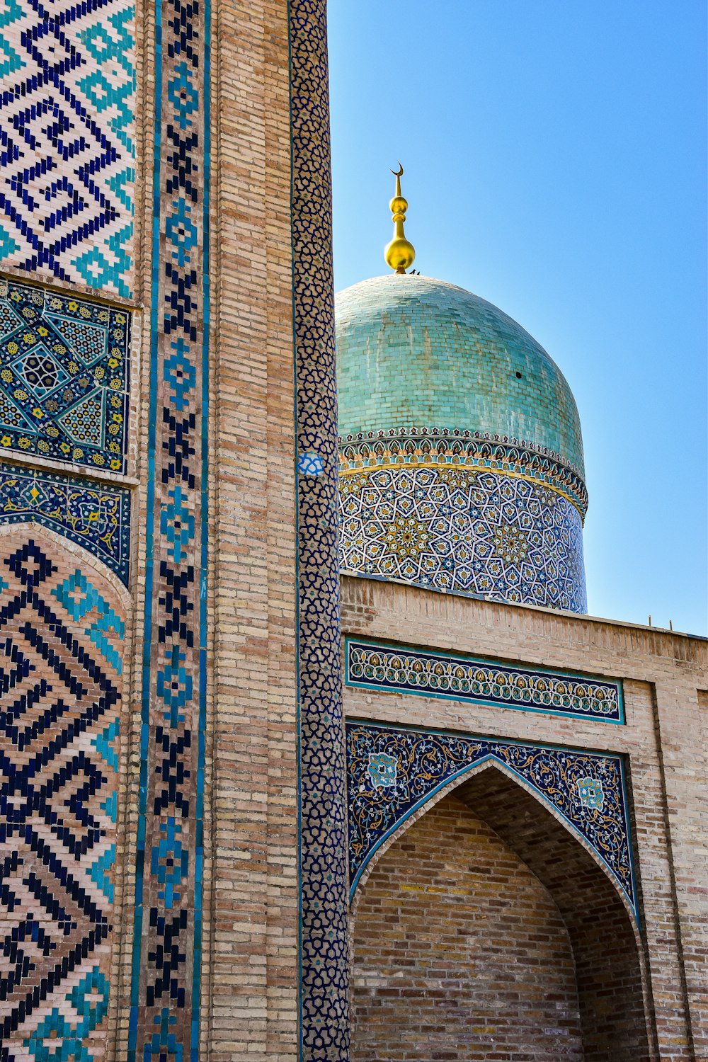 a tall building with a blue dome and a blue sky in the background