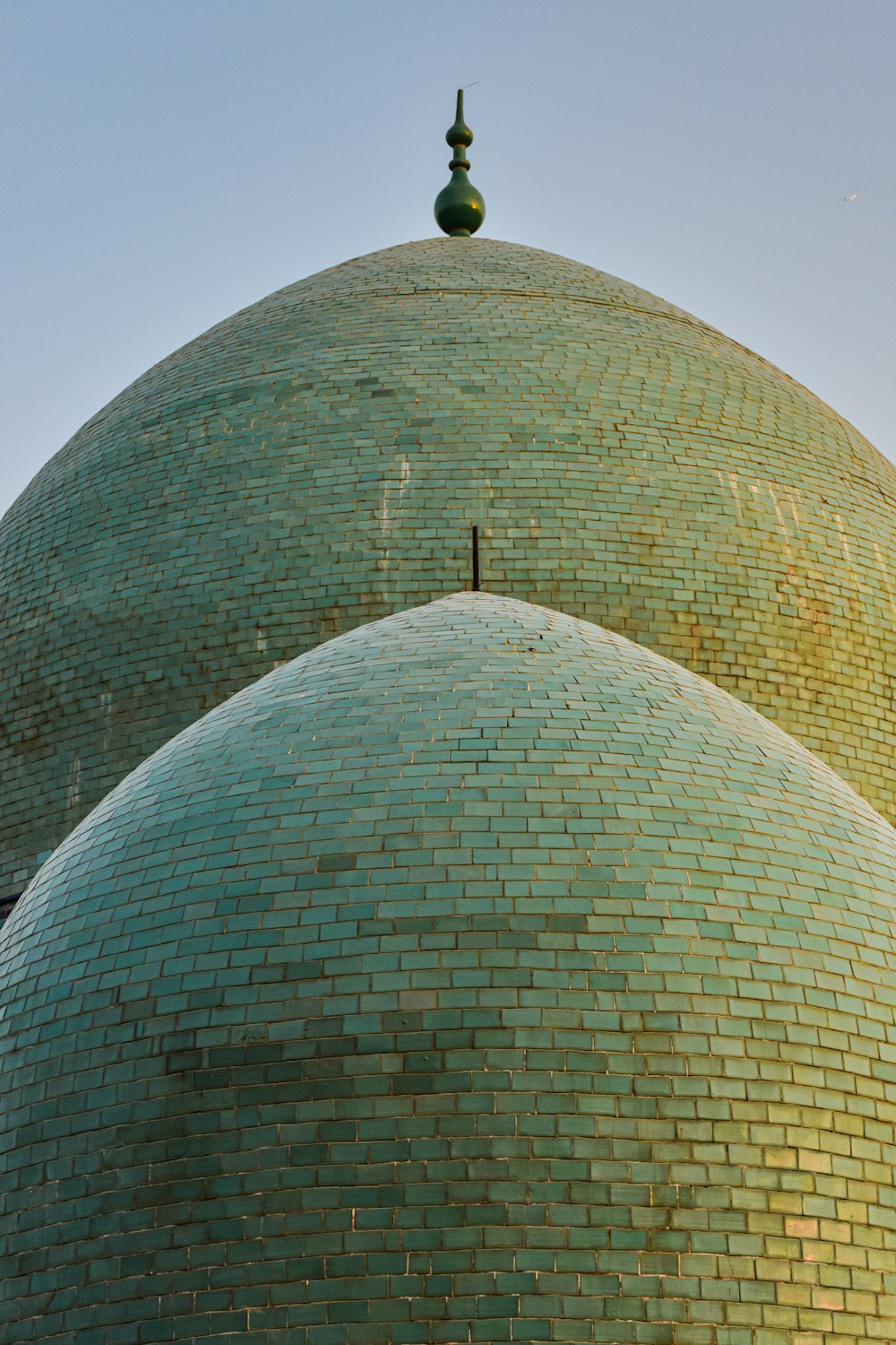 a large green dome with a cross on top of it