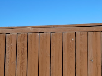 a wooden fence with a blue sky in the background