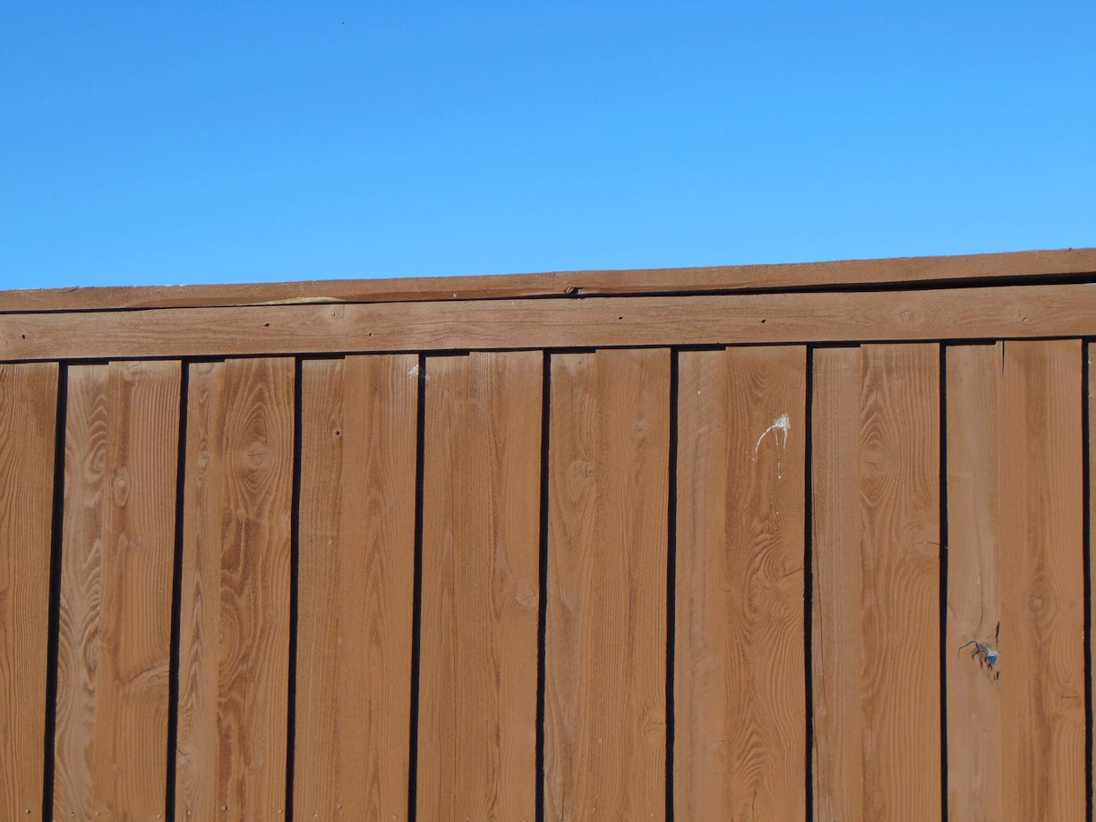 a wooden fence with a blue sky in the background