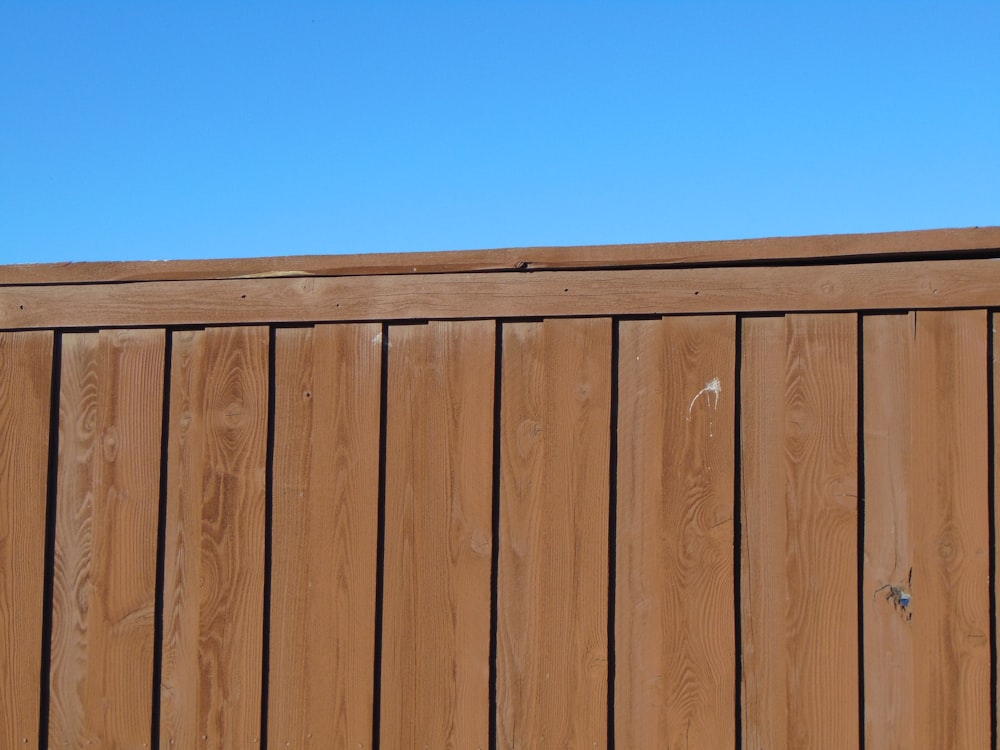 a wooden fence with a blue sky in the background