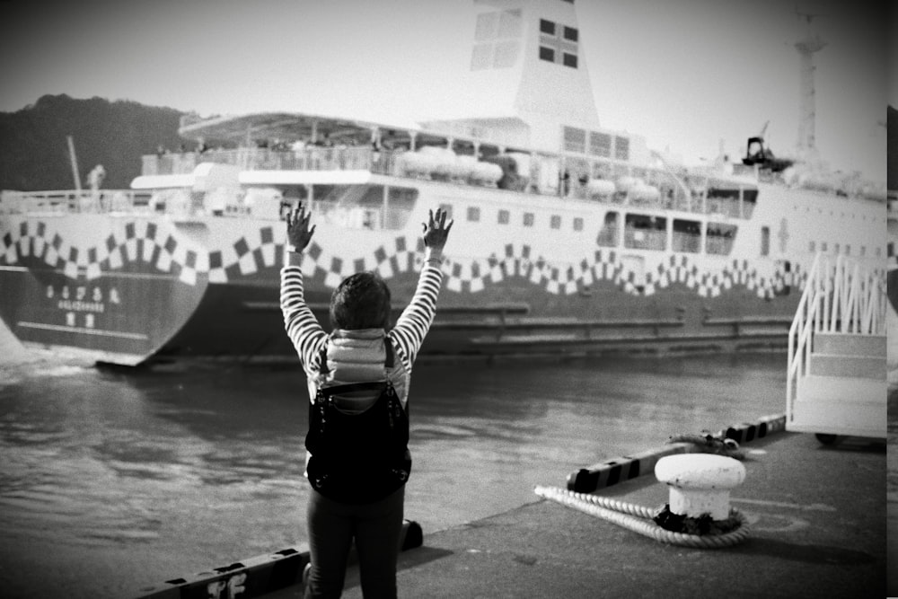 a black and white photo of a woman raising her hands