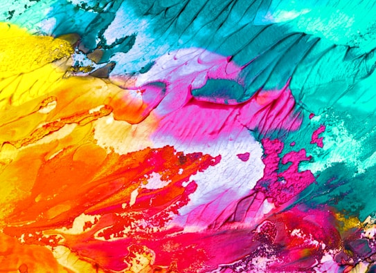 A vibrant abstract image with a blend of different colors creating a visually dynamic texture. The composition features bold strokes of teal, pink, orange, yellow, and red, with some areas showing a textured, almost three-dimensional effect.