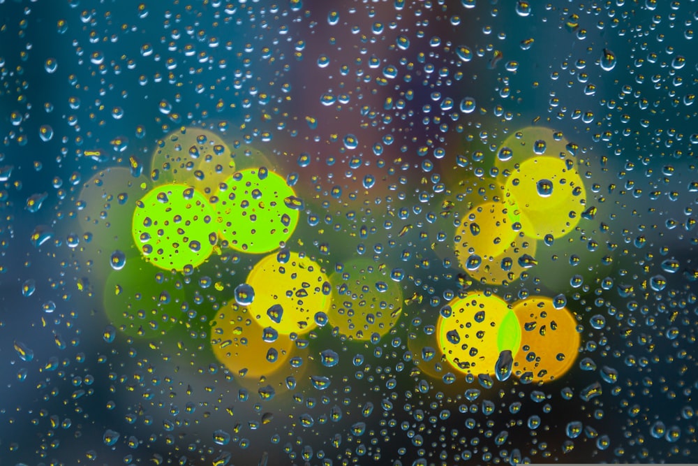 gotas de chuva em uma janela com semáforos ao fundo