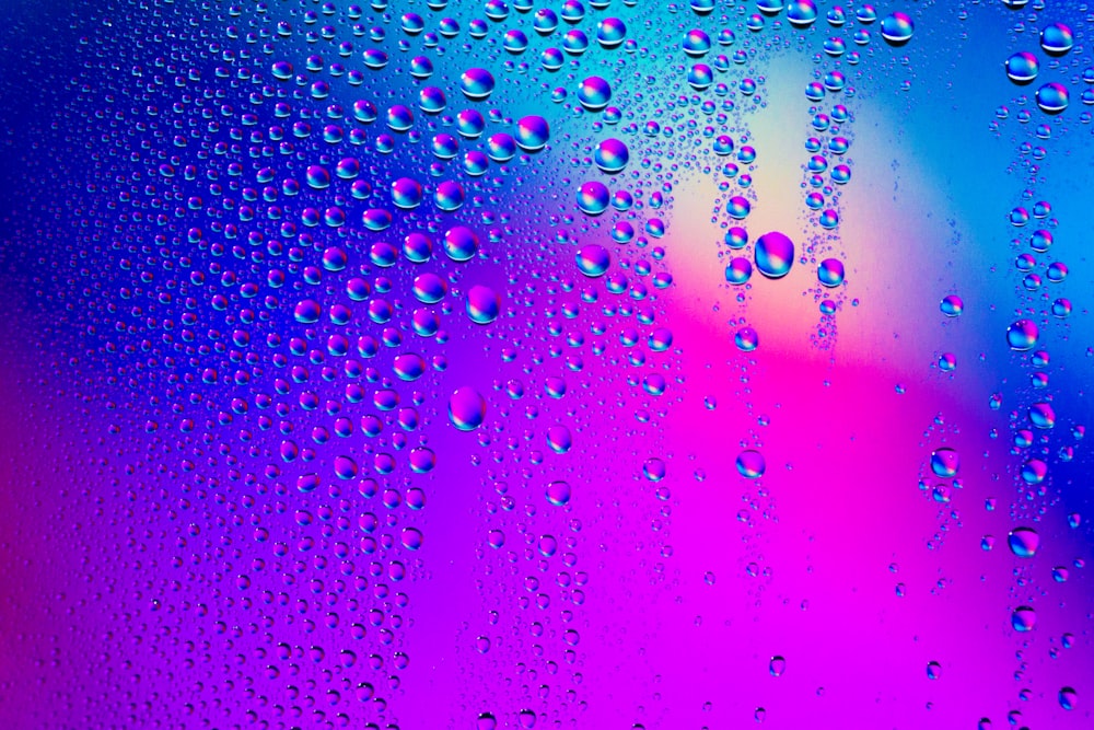 gotas de água em uma janela com um fundo colorido
