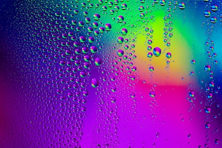 a rainbow colored background with water droplets