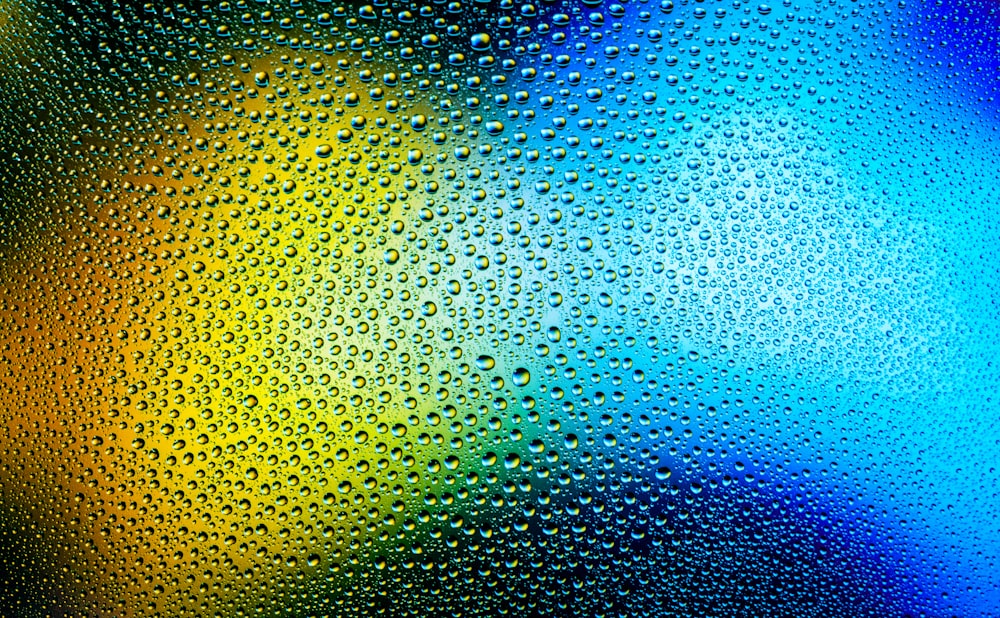 water droplets on a glass surface with rainbow colors