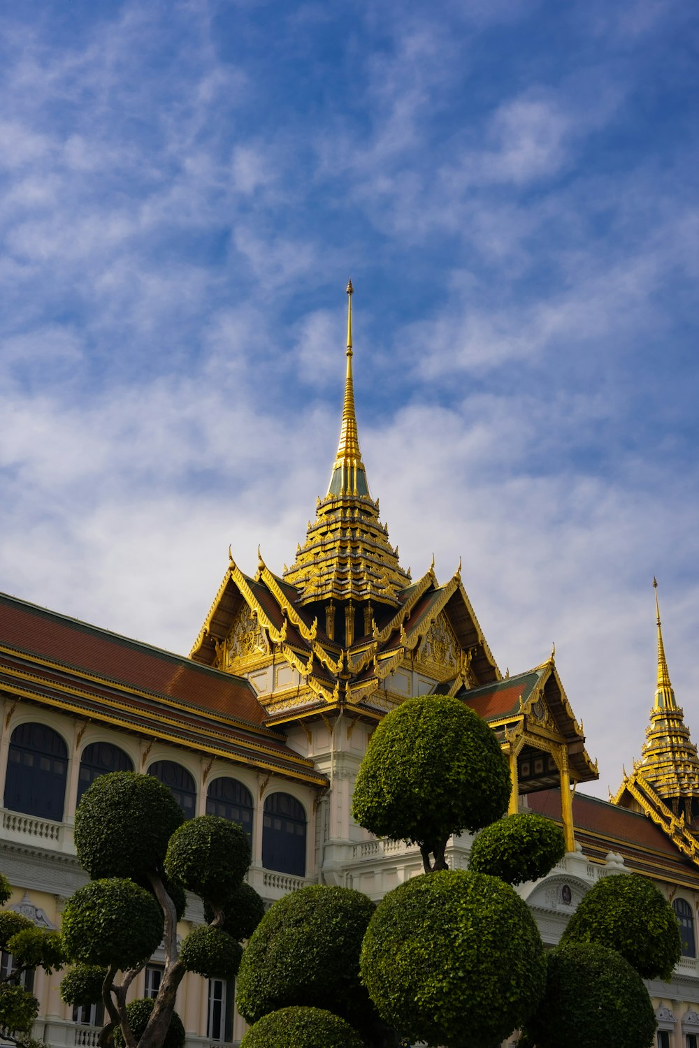 a large building with a golden roof and a tree in front of it