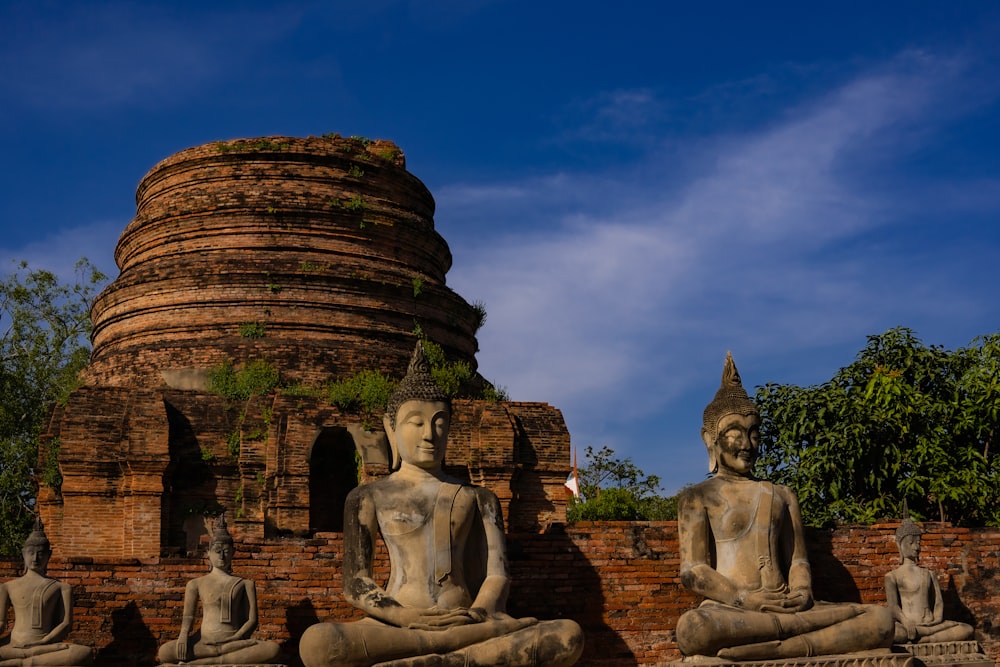 a group of buddha statues sitting next to each other