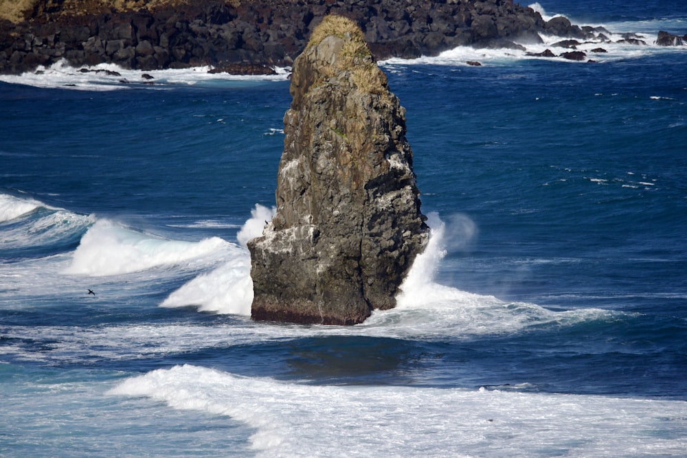 a large rock sticking out of the ocean