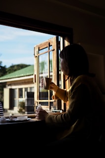 A cozy scene of a person enjoying a warm cup of herbal tea by a sunny window.