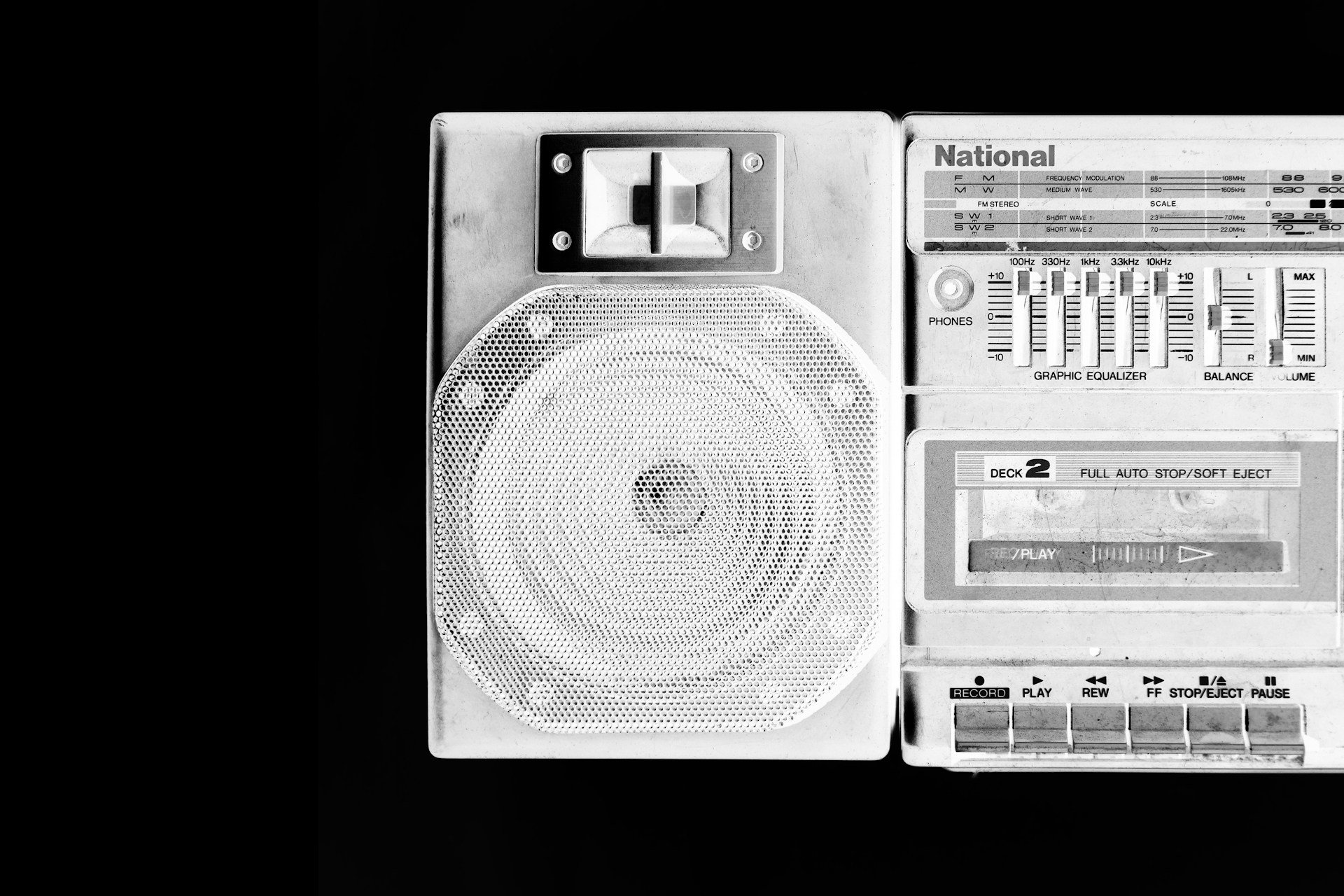 A retro-style stereo system featuring a speaker and cassette player with a graphic equalizer and multiple controls. Labels such as 'National' are visible, and the design is predominantly monochrome with a focus on contrasting tones.