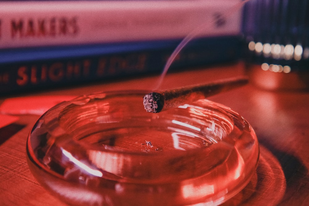 a glass ashtray sitting on top of a wooden table