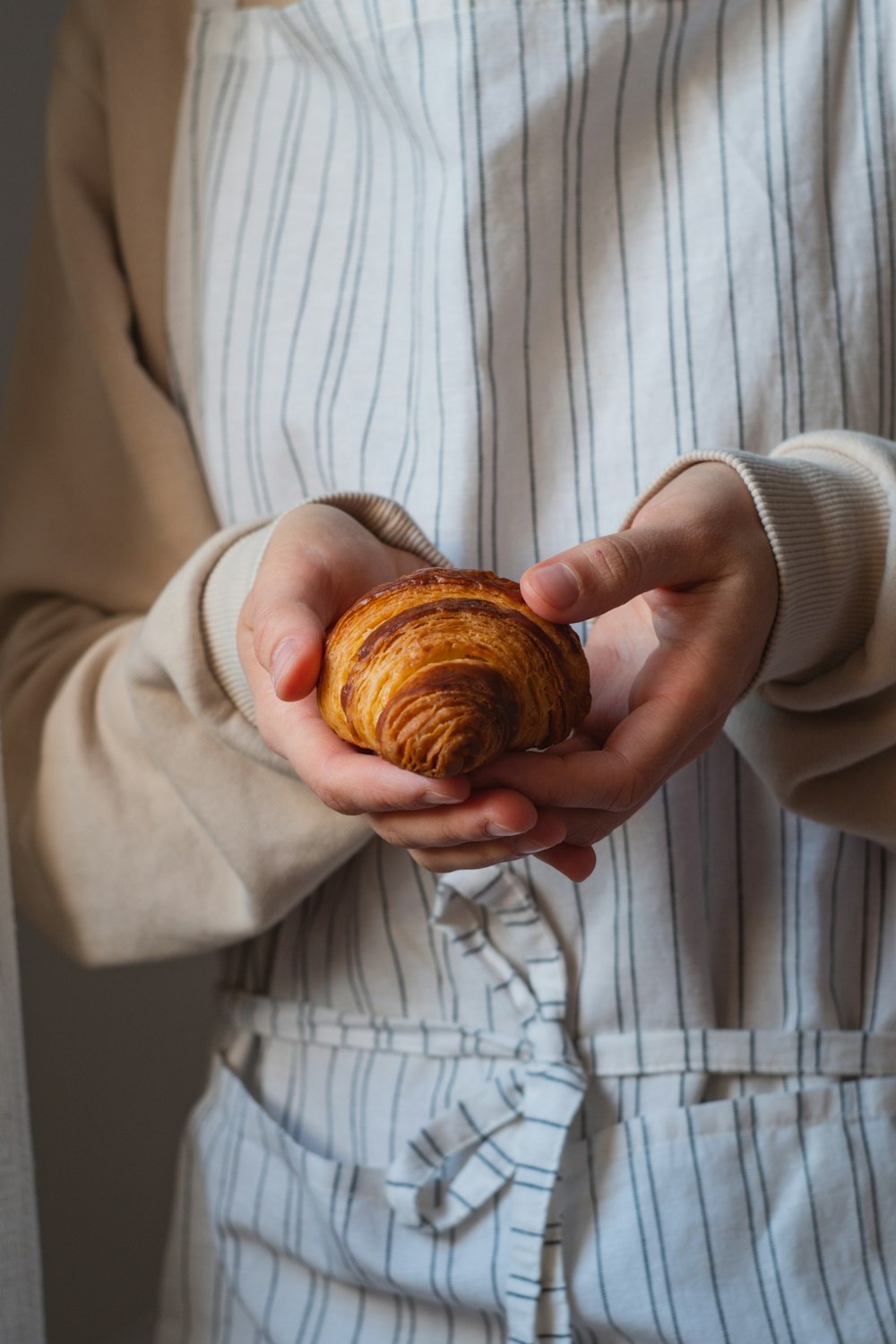 a person holding a pastry in their hands