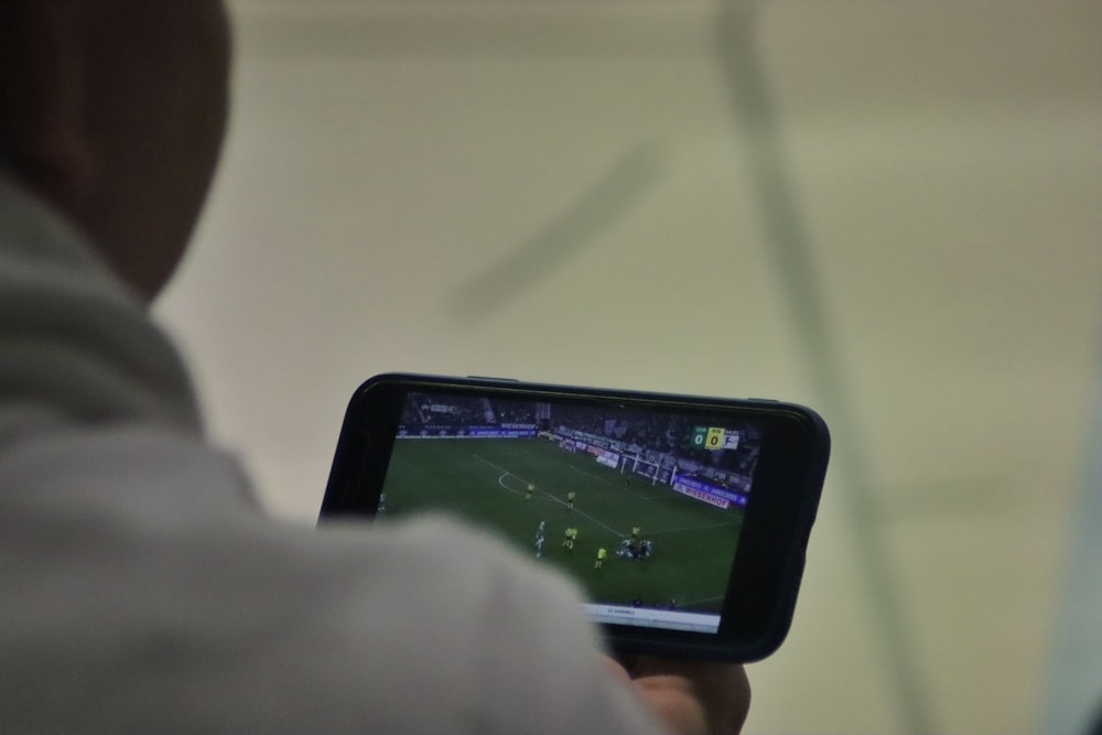 a man is playing a soccer game on his phone