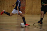 Players training in a sleek, minimalist futsal session with a city skyline backdrop.